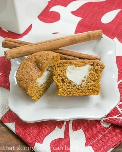 A Cream Cheese Filled Pumpkin Muffin cut open on a small white plate.