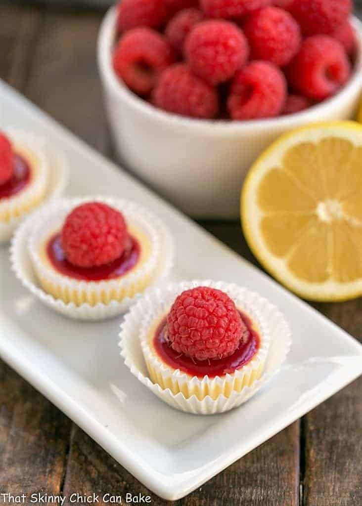 Raspberry Topped Mini Cheesecakes on a white platter.