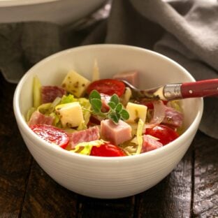 Italian chopped salad in a small bowl with a fork.