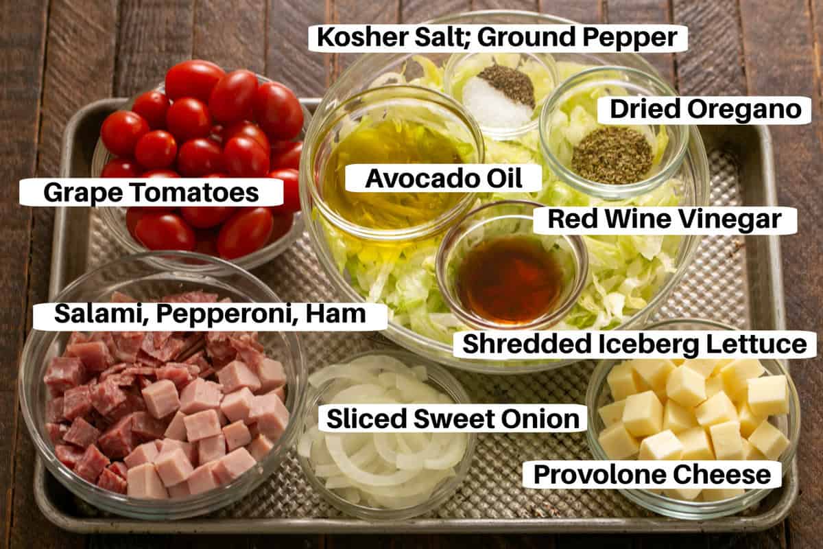 Sub-chopped Italian salad ingredients with labels on a metal sheet tray.