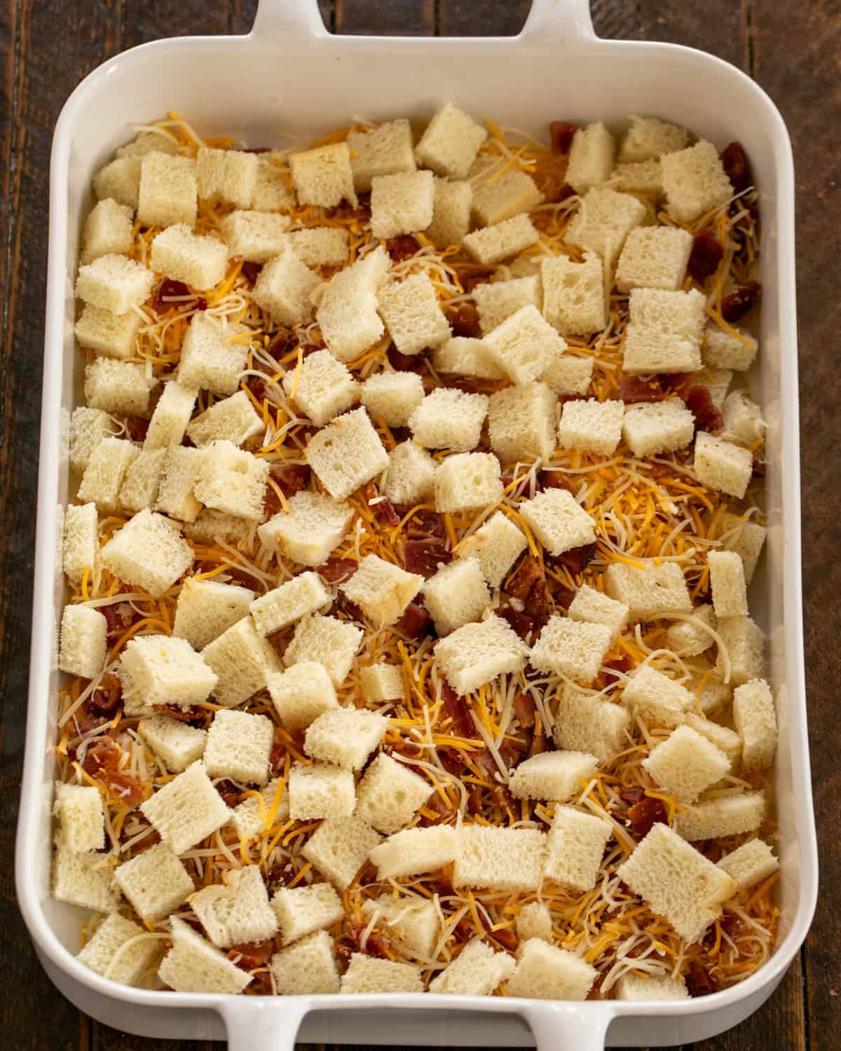 Bread cubes, bacon and cheese in the baking dish.