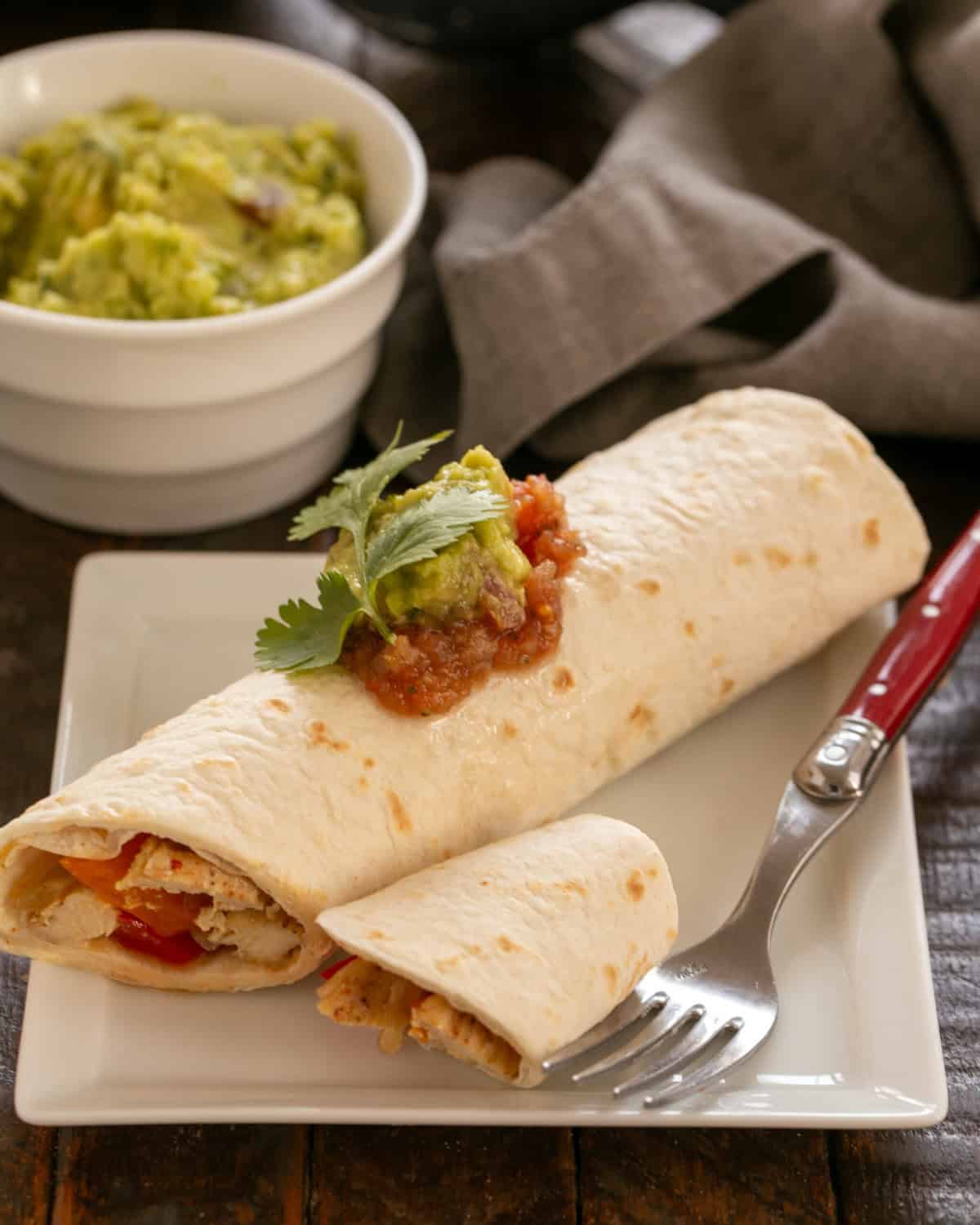 Easy Chicken Fajitas Recipe on a white pate with a red handled fork.